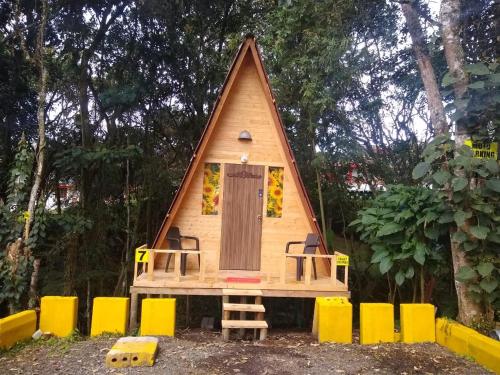 a small tree house with a door and two chairs at Hospedaje Santaelena -chalets de montaña- in Santa Elena