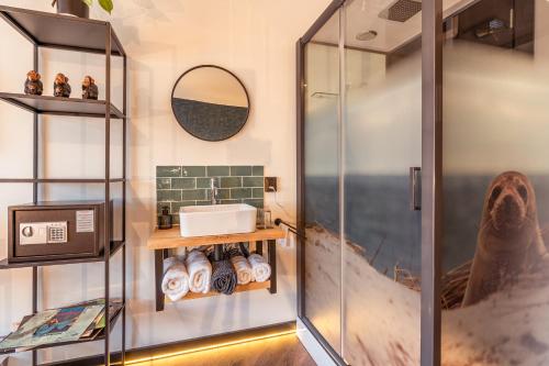 La salle de bains est pourvue d'une douche et d'un lavabo. dans l'établissement Hotel De Werf, à Le Helder
