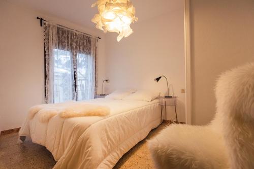 a bedroom with two beds and a chandelier at JAT Mountain Houses - Casa Agustí 3er pis - Cèntric, al costat del Telecabina de Canillo in Canillo