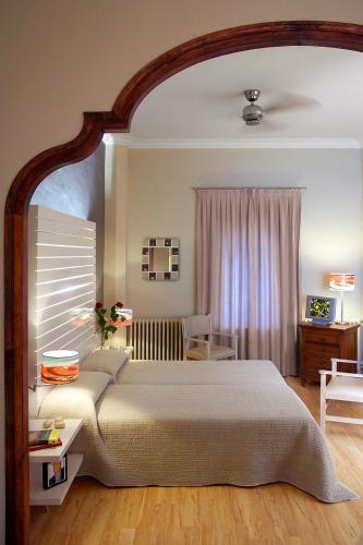 a bedroom with a large bed and a table and chair at Hotel Mar de Tasmània - Auto Check-in in La Bisbal