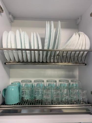 a shelf with plates and glasses in a refrigerator at Зручні апартаменти подобово! Центр. Руська. 3 кімн. in Ternopilʼ