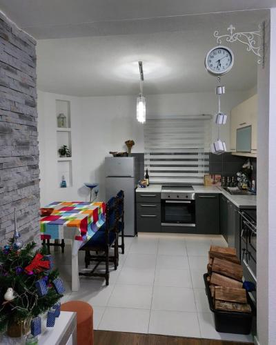 a kitchen with a stove and a table with chairs at Guest house Vlahovic in Kolašin