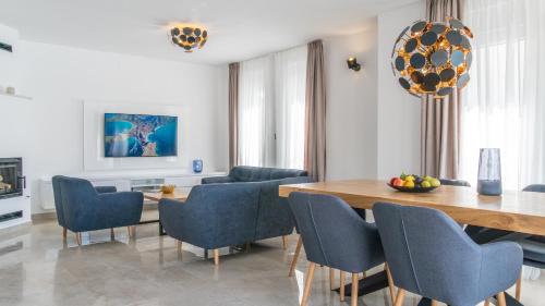 a dining room with a table and blue chairs at Villa DEA - Dein Rückzugsort am Meer mit beheiztem Pool in Vrsi