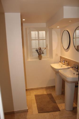 une salle de bain avec deux lavabos et une fenêtre dans l'établissement Villa Alexandra, à La Croix-Valmer