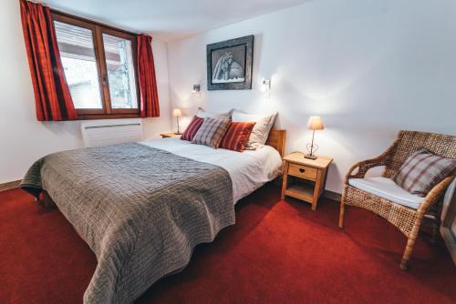 a bedroom with a bed and a chair at Appartement Orion by ExplorHome in Tignes