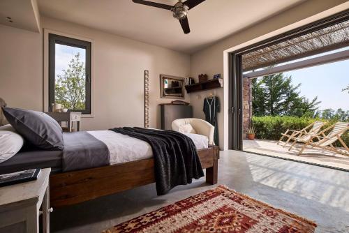 Schlafzimmer mit einem Bett und einer Glasschiebetür in der Unterkunft Aegina Retreat in Tzíkidhes