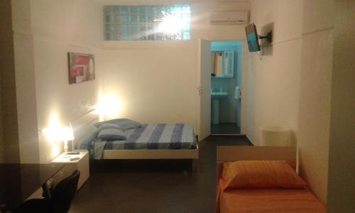 - une petite chambre avec un lit et un couloir dans l'établissement Ipanema Suite, à Margherita di Savoia