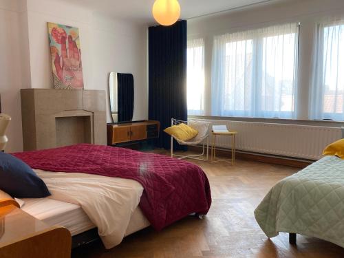 Un dormitorio con una cama grande y una chimenea. en Family Floor - La Couronne Oostende - Authentiek appartement met veel lichtinval, en Ostende