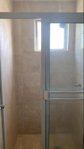 a shower with a glass door in a bathroom at Departamento en Torre Miramar, Malecón de Mazatlán in Mazatlán