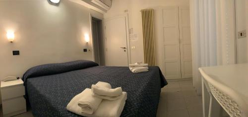 a bedroom with a bed and a sink and towels at Hotel Marylise in Rimini