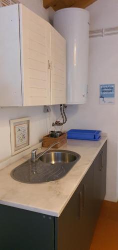 a kitchen counter with a sink and white cabinets at Monte das Aranhas in Estremoz