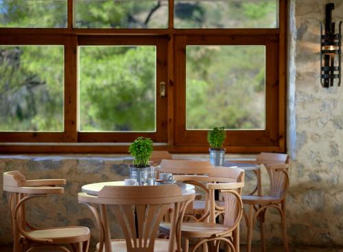 a row of tables and chairs in a room with windows at Atrium Hotel in Agia Paraskevi