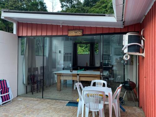 un patio con sedie bianche, un tavolo e un edificio di Casa Ribeirao da Ilha a Florianópolis