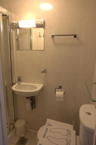 a small bathroom with a sink and a toilet at Central Hotel in London