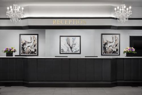 a hotel lobby with a reception counter with four pictures at The Manhattan at Times Square in New York