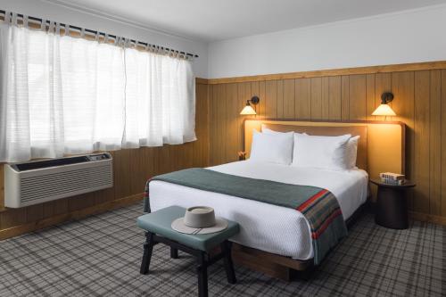 a hotel room with a bed and a small stool at The Virginian Lodge in Jackson