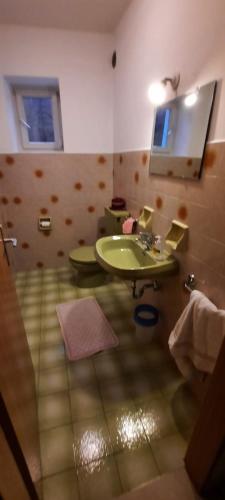 a bathroom with a green sink and a mirror at Hof am Brunnen in Cornaiano