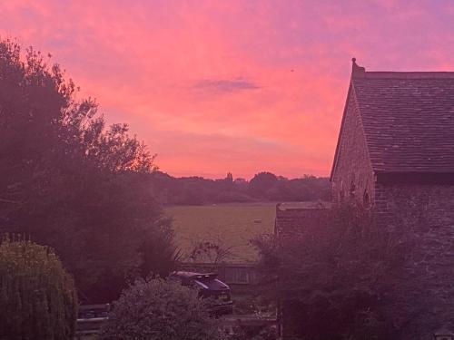 a red sky with a barn and a house at Old Chapel Forge in Chichester