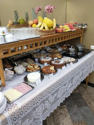 a table with a bunch of food on it at Hotel Cidade in Passos