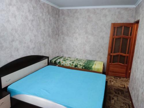 ナーベレジヌイェ・チェルヌイにあるApartment on Kol Galiのベッドルーム(青いベッド1台、木製の棚付)