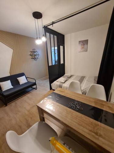 sala de estar con sofá y mesa en Appartement proche lac Longemer, en La Bresse