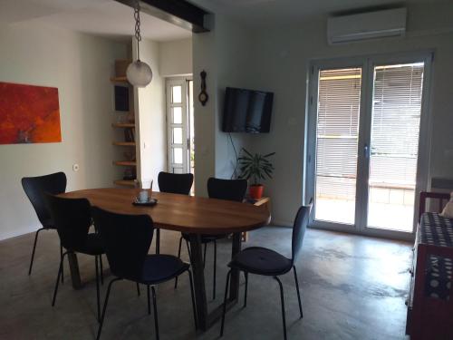 Apartment Kuca Merdzo في أوربيك: غرفة طعام مع طاولة وكراسي خشبية