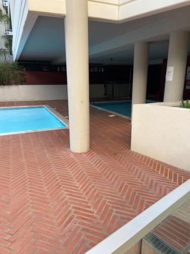 un bâtiment avec une piscine et deux colonnes dans l'établissement 2 pièces avec terrasse et piscine cannes Croisette, à Cannes