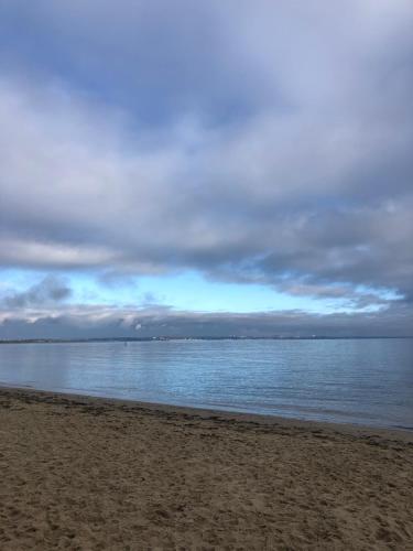 a beach with a cloudy sky and the water at Purbeck Hill View in Swanage