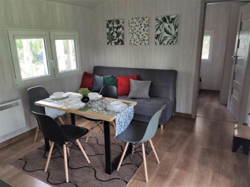 ein Wohnzimmer mit einem Tisch und einem Sofa in der Unterkunft domki przy lipowej 16 in Łuka