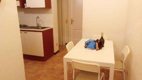 una cocina con una mesa blanca y una botella de vino en Verde e mare, en La Spezia