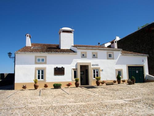 uma casa branca com vasos de plantas em frente em El-Rei Dom Manuel Hotel em Marvão