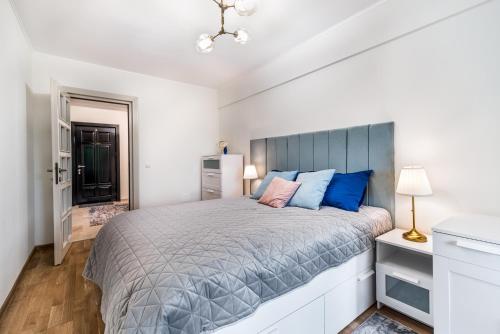 um quarto com uma cama grande e almofadas azuis em DreamGarden Airport apartment & Secure parking & Airport shuttle em Iaşi