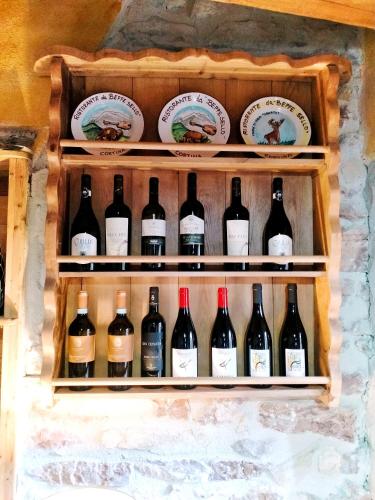 a display of wine bottles and plates on a wall at Maison en Pierre in Fiastra