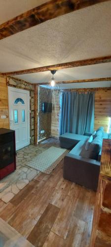 a large living room with a couch and a tv at Durmitorske zore in Žabljak