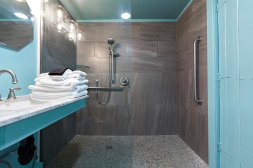 a bathroom with a shower and a sink with towels at The Cornell Inn, Lenox & The Berkshires in Lenox