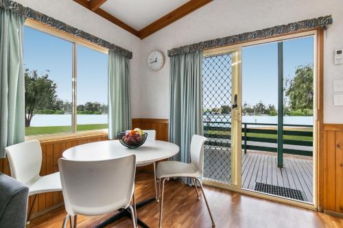 a dining room with a table and chairs and large windows at BIG4 Mannum Holiday Park in Mannum