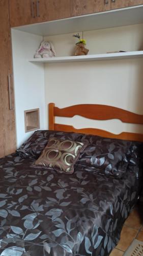 1 dormitorio con 1 cama con edredón negro en Condomínio Sol de Verao, en Florianópolis