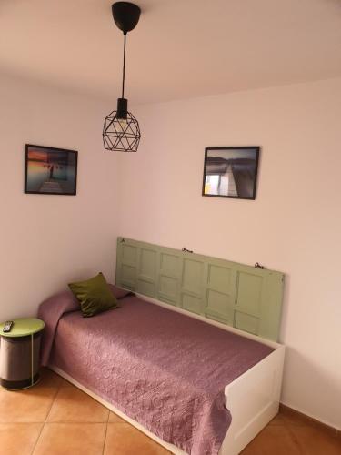 - une chambre avec un lit et une couverture violette dans l'établissement Home Favorito, à Tarajalejo