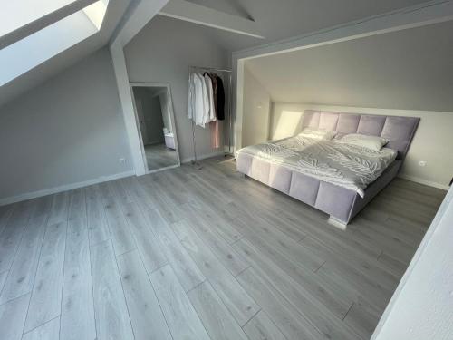 a bedroom with a bed and a wooden floor at Apartament LuxLook in Nowy Sącz