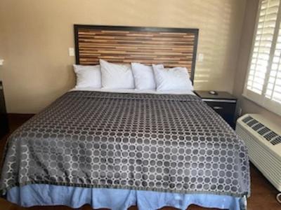 a bedroom with a large bed with a wooden headboard at RUBY MOTEL in Long Beach