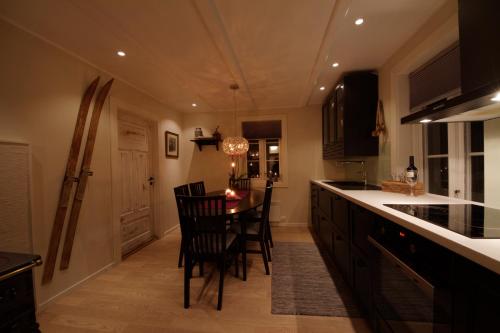 a kitchen with a table and chairs in a kitchen at Kjosen Lodge, Lyngen. in Lyngseidet