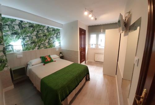 a bedroom with a bed and a large painting on the wall at Verdemar Rooms in Gijón