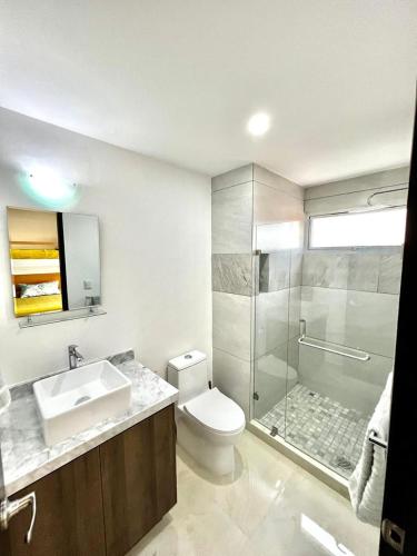 a bathroom with a toilet and a sink and a shower at Sunset View Malecón 1401 Vista panoramica al mar in Mazatlán