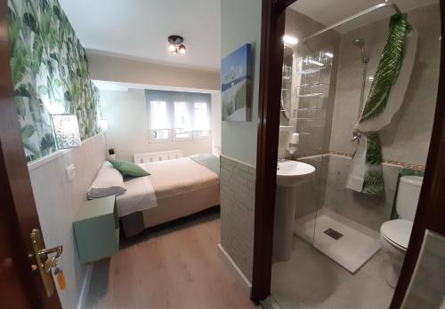 y baño con cama, lavabo y aseo. en Hostal Verdemar, en Gijón