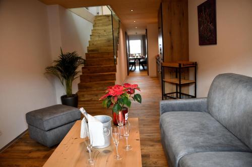 a living room with a couch and a table with flowers at Hôtel de Ville in Gruyères