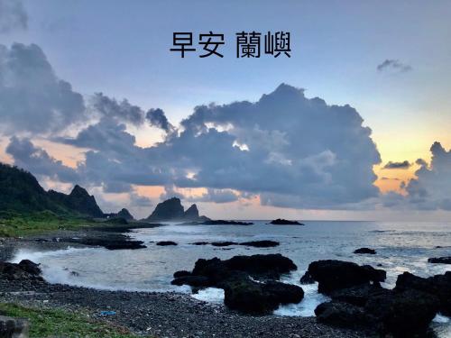 a sunset over the ocean with rocks in the water at 鄉間小路 in Lanyu