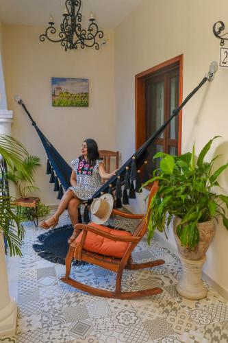 a woman sitting on a hammock in a room at Le Muuch Hotel Boutique in Valladolid