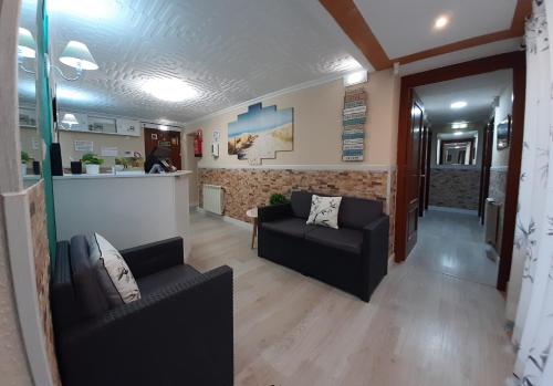 sala de estar con sofá y bar en Hostal Verdemar, en Gijón