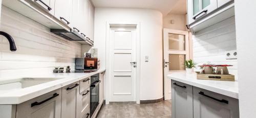 a kitchen with white cabinets and a sink at City Vibe in Brčko