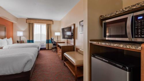 a hotel room with two beds and a microwave at Best Western Cannon A.F.B. in Clovis